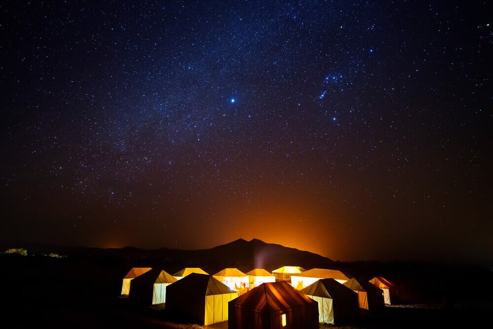 Un cielo estrellado en el campamento del desierto durante un tour de 3 días, con tiendas de campaña iluminadas bajo un firmamento nocturno  - View 4